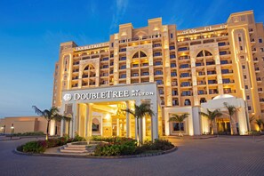 Ein großes, mehrstöckiges Hotel mit einer markanten Eingangshalle, Balkonen und einer gut beleuchteten Fassade.
