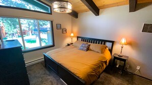 Une chambre à coucher avec un lit, deux lampes de chevet, une fenêtre et un bureau.