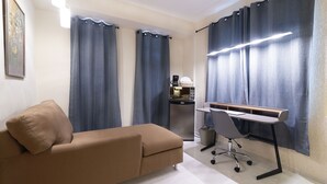 A modern room with a sofa, a desk, and a coffee machine. - Suites Nader by The Spot (Cancun)