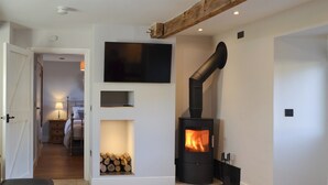 A modern living room with a fireplace, a television mounted on the wall, and a cozy seating area.