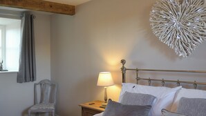 A neatly made bed with pillows, a bedside lamp, and a decorative wall piece.