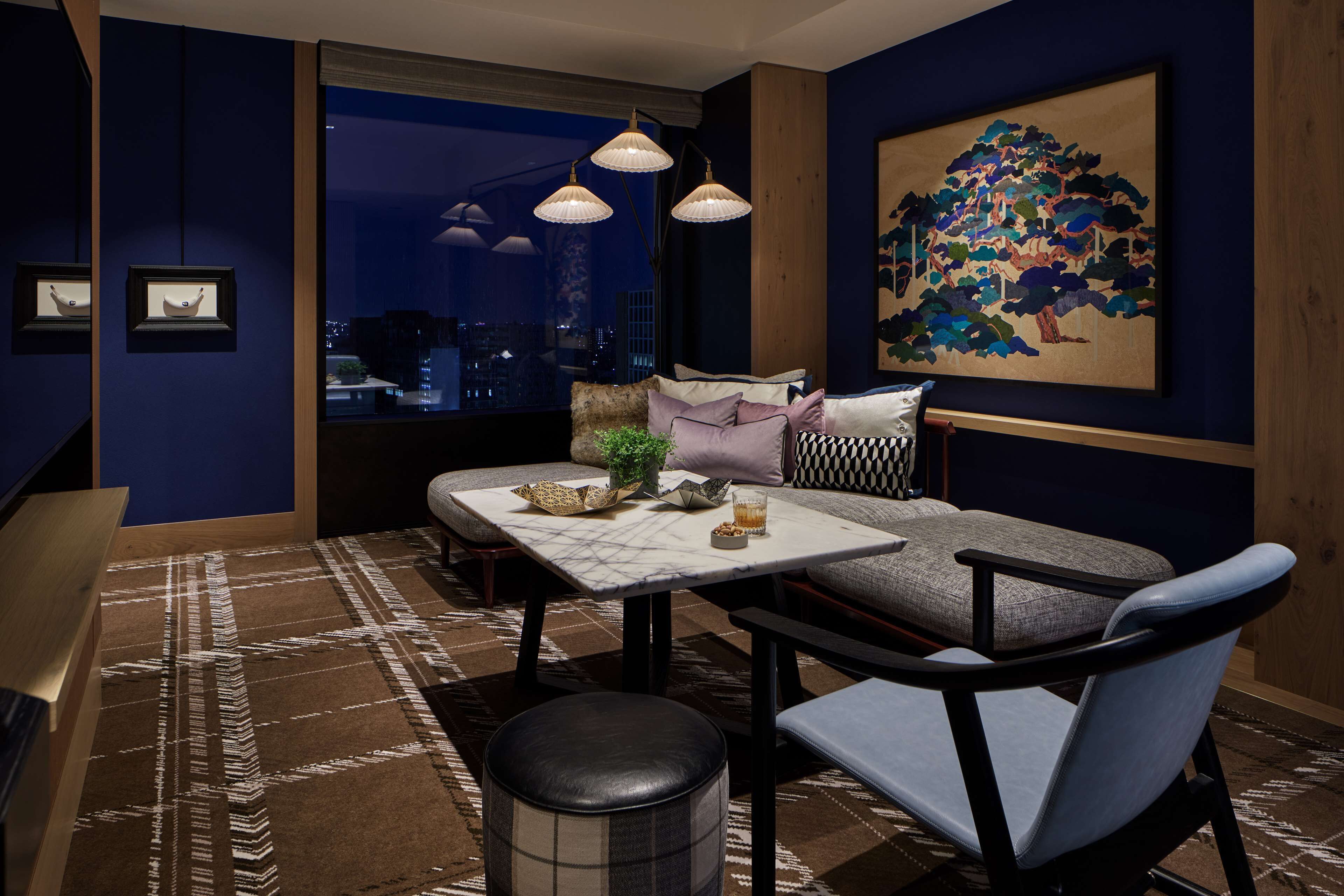A modern living room with a sofa, a dining table, and a large window.