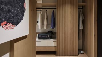 Una habitación moderna con un armario de madera, un escritorio con una maleta y un perchero.