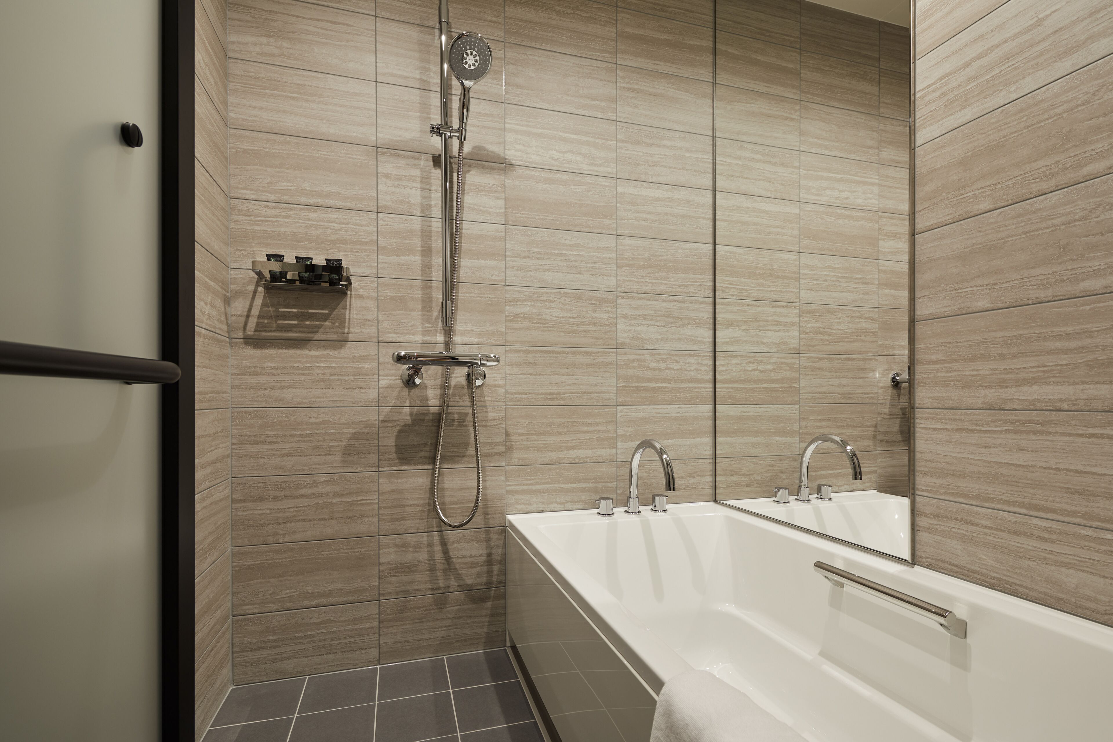 A modern bathroom with a bathtub, a shower, and a mirror.
