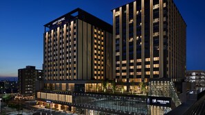 A modern hotel with a prominent 'Hyatt Centric' sign, a glass facade, and a 'Cross Gate Kanazawa' sign below.