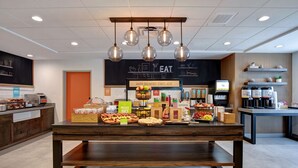 A breakfast buffet area with a variety of food items and a sign indicating 'HAPPY BREAKFAST STARTS HERE'.