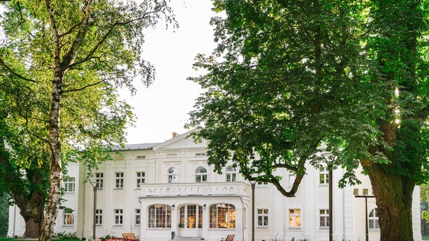 A large, white building with a symmetrical facade, large windows, and a central entrance. - Kasztanowy Pałac (Tarnowo Podgorne)