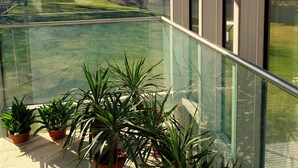 A balcony with a glass railing overlooking a golf course. - Kasztanowy Pałac (Tarnowo Podgorne)