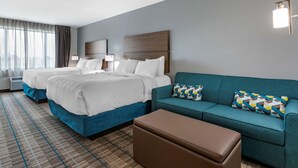 A hotel room with two beds, a sofa, and a small table. - MainStay Suites Waukee - West Des Moines (Waukee)