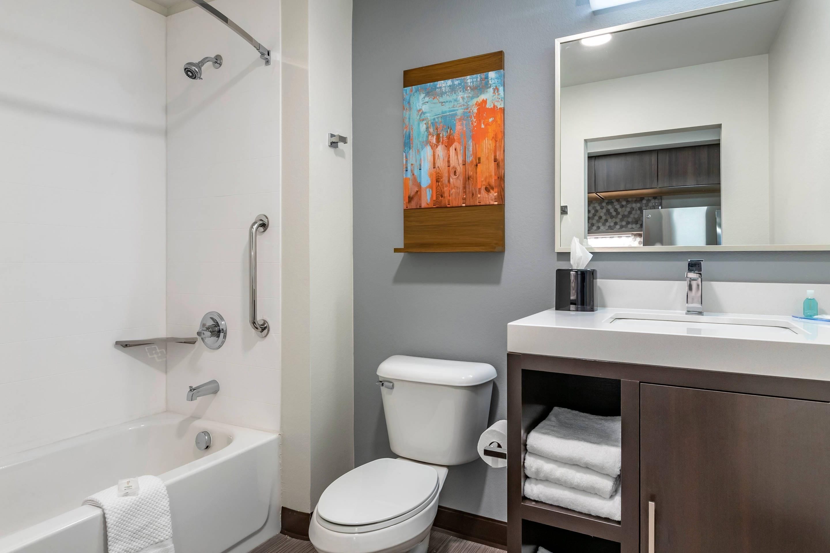 Une salle de bain moderne équipée d’une baignoire, de toilettes et d’un lavabo.