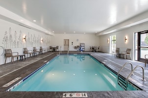 Una piscina con un indicador de profundidad de 1,4 metros, rodeada de sillas de descanso y una pared con motivos florales.