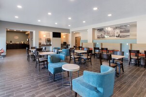 Un restaurante moderno con diversas opciones de asientos, incluyendo mesas, sillas y sofás.