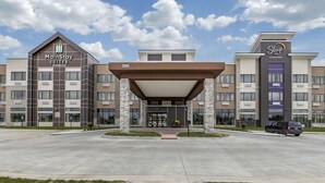 A hotel with MainStay Suites and Sleep Inn by Choice Hotels. It features a modern design with a covered entrance and a parking lot. - MainStay Suites Waukee - West Des Moines (Waukee)