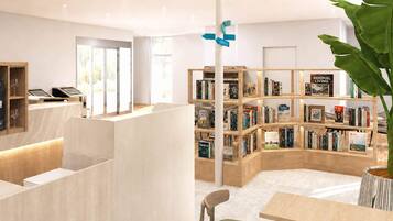 A modern library with bookshelves, a checkout counter, and seating areas.