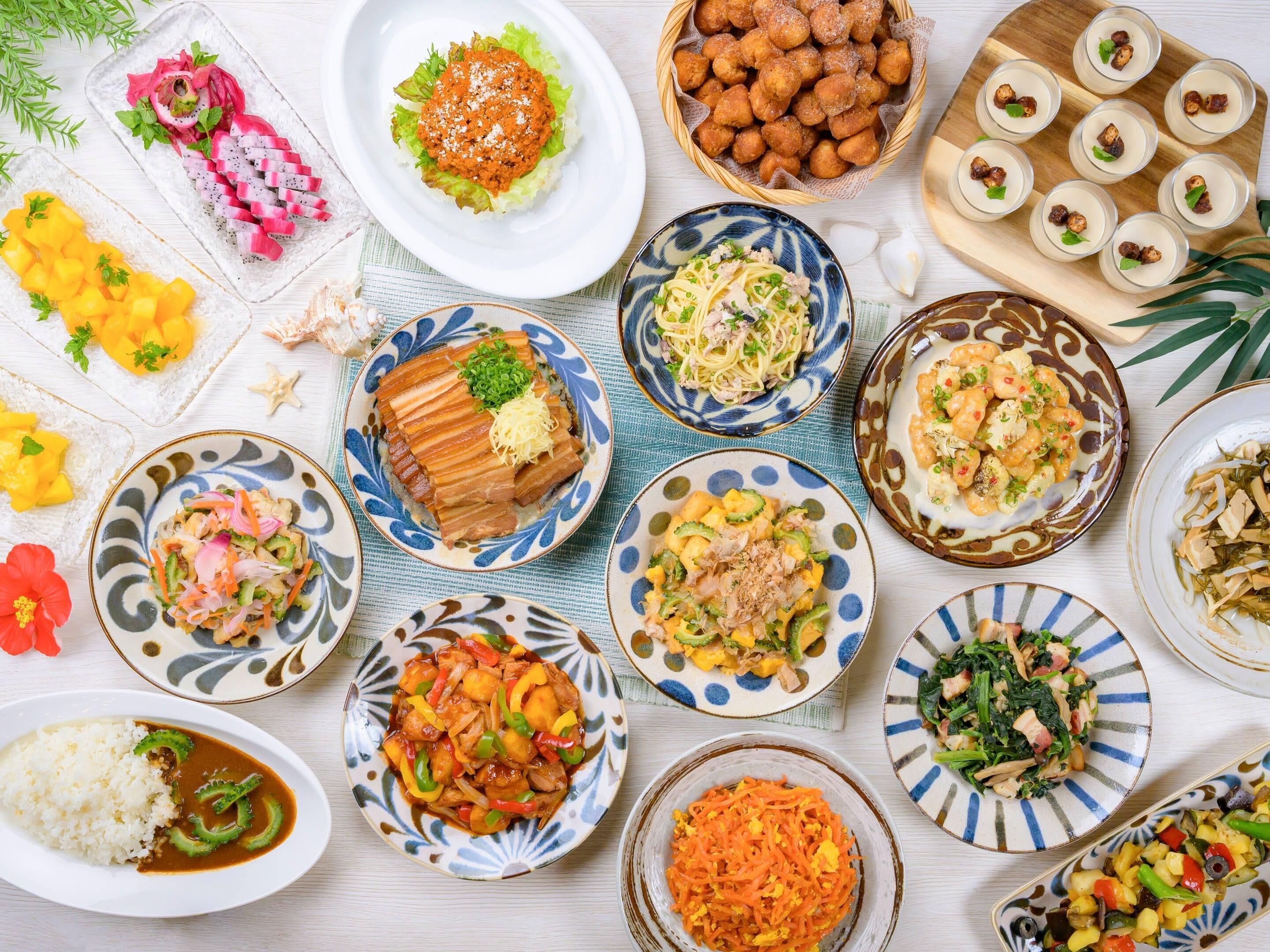 A variety of dishes on a table, including sushi, rice, and vegetables.