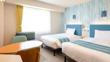 Relax in a clean and modern space with two single beds, a dining table, and a large window.