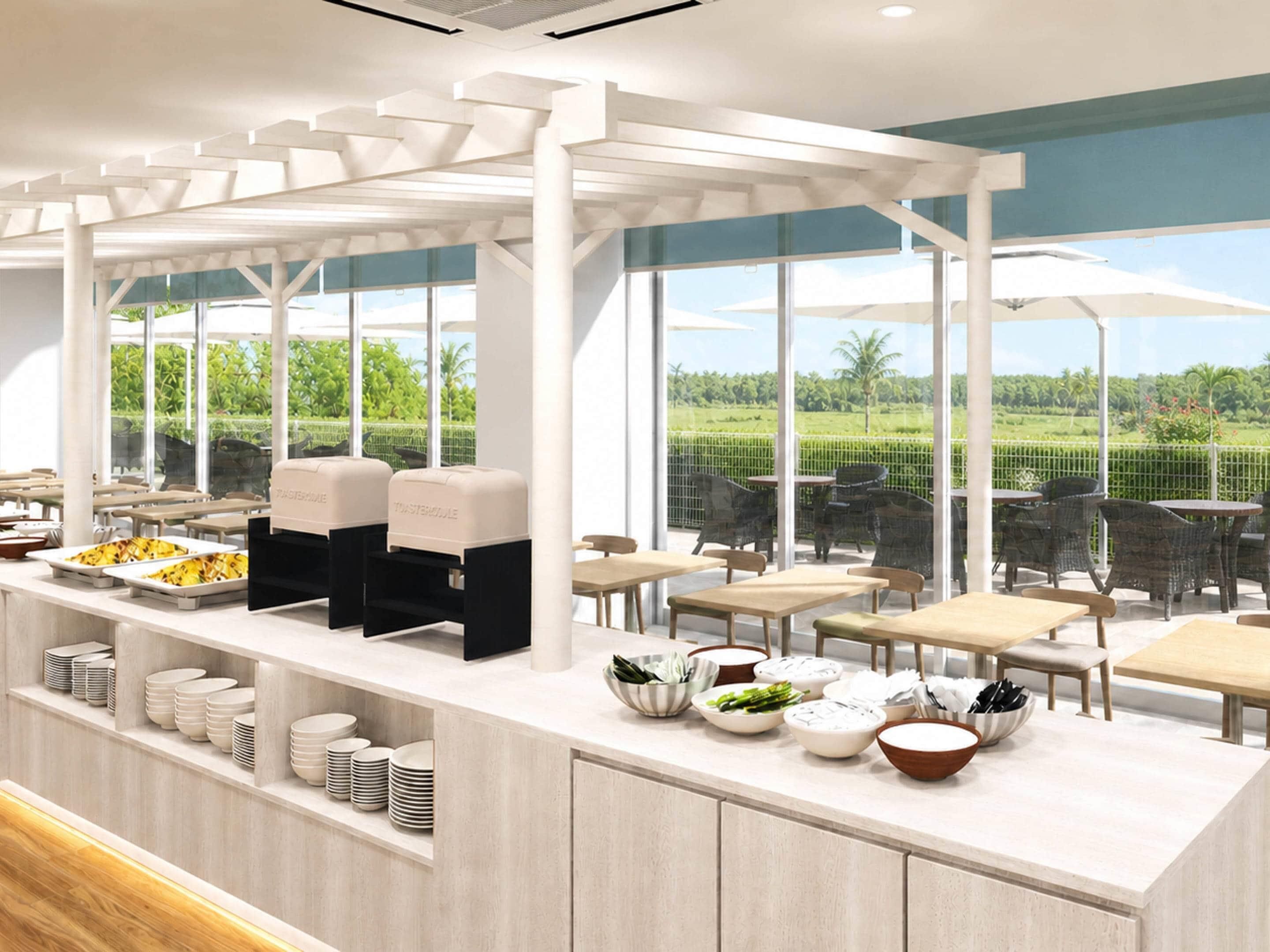 Una cafetería moderna con mostrador, platos, tazones y vistas a zonas verdes.