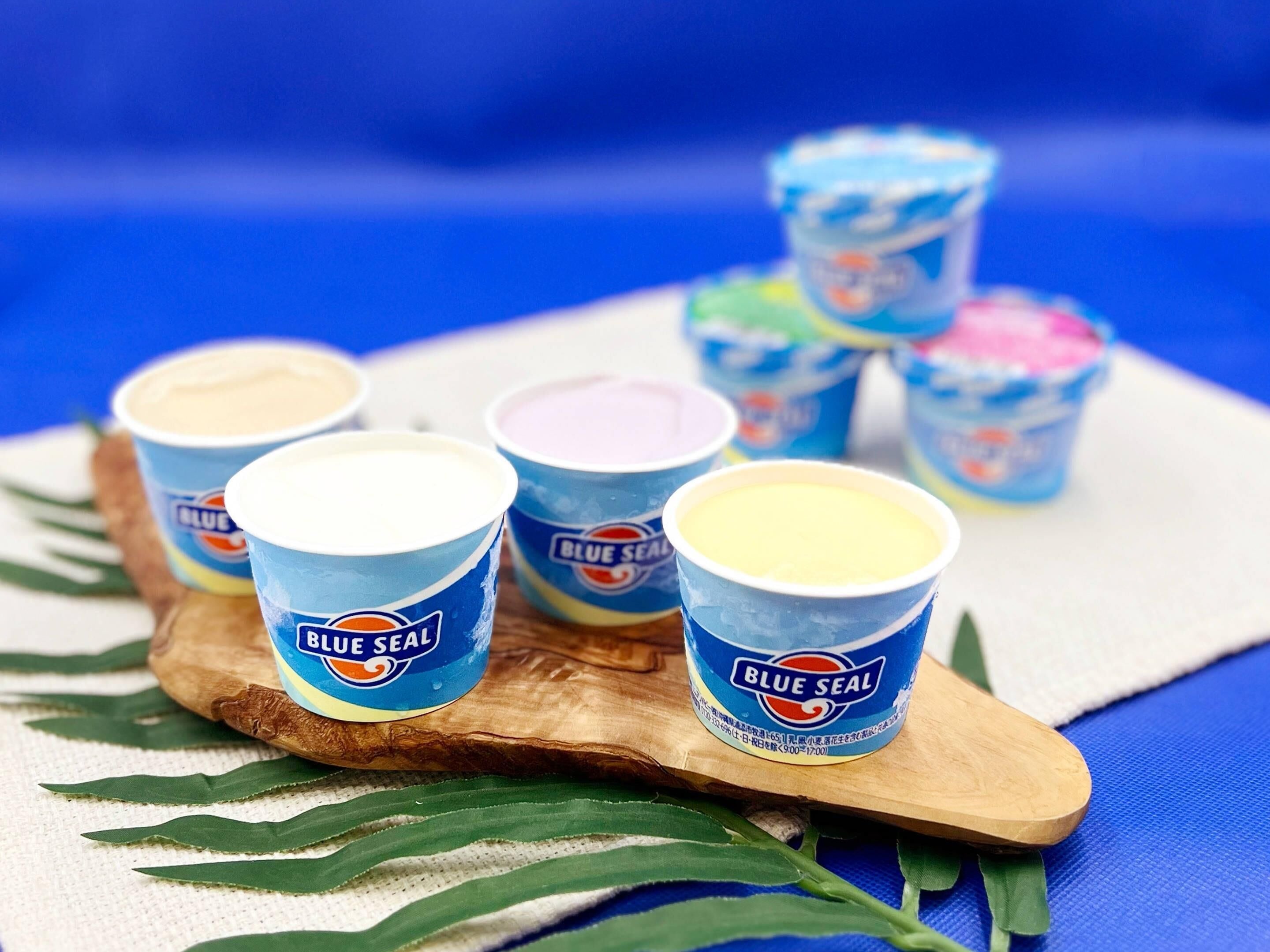Seis recipientes de helado Blue Seal sobre una tabla de madera.
