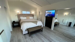 A bedroom with a large bed, a TV, and a mirror. - Catalina Two Bedroom, Two Bath  View Home (Avalon)