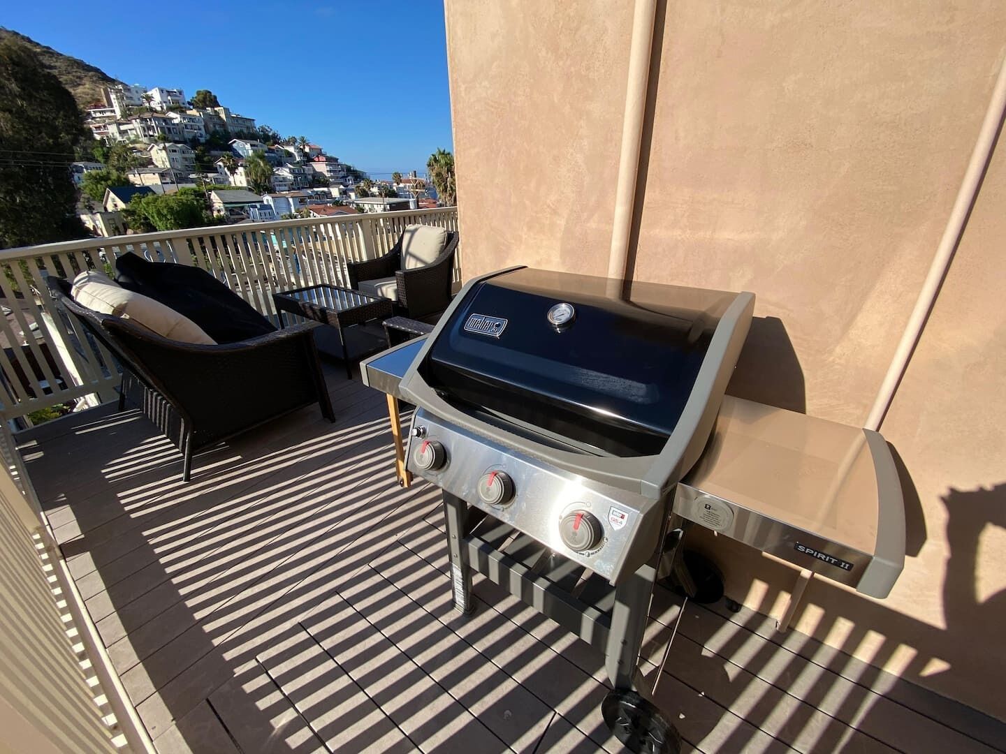 Una parrilla al aire libre en un balcón con vista a un pueblo en la ladera.