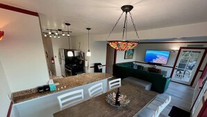 A modern kitchen with a wooden island, white cabinetry, and pendant lighting. - Catalina Two Bedroom, Two Bath  View Home (Avalon)