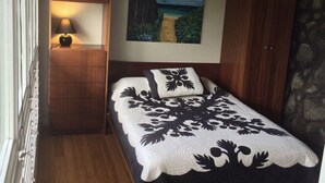 Une chambre à coucher avec un lit, un tableau, une table de chevet et une lampe.