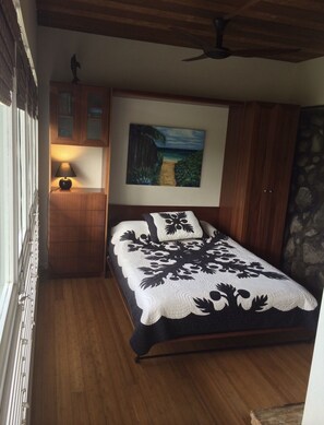 Un dormitorio con cama, un cuadro, una mesita de noche y una lámpara.