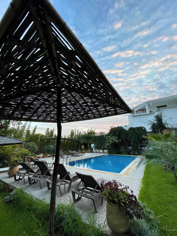 A pool area with lounge chairs and a pergola structure. - Dar Tanja (Tangier)