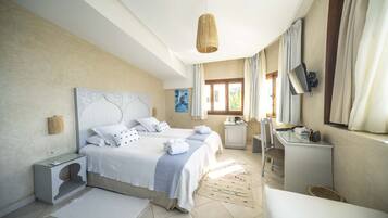 A bedroom with a large bed, bedside tables, a desk, and a chair.
