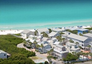 A coastal hotel with multiple buildings, a beach, and a clear view of the ocean.