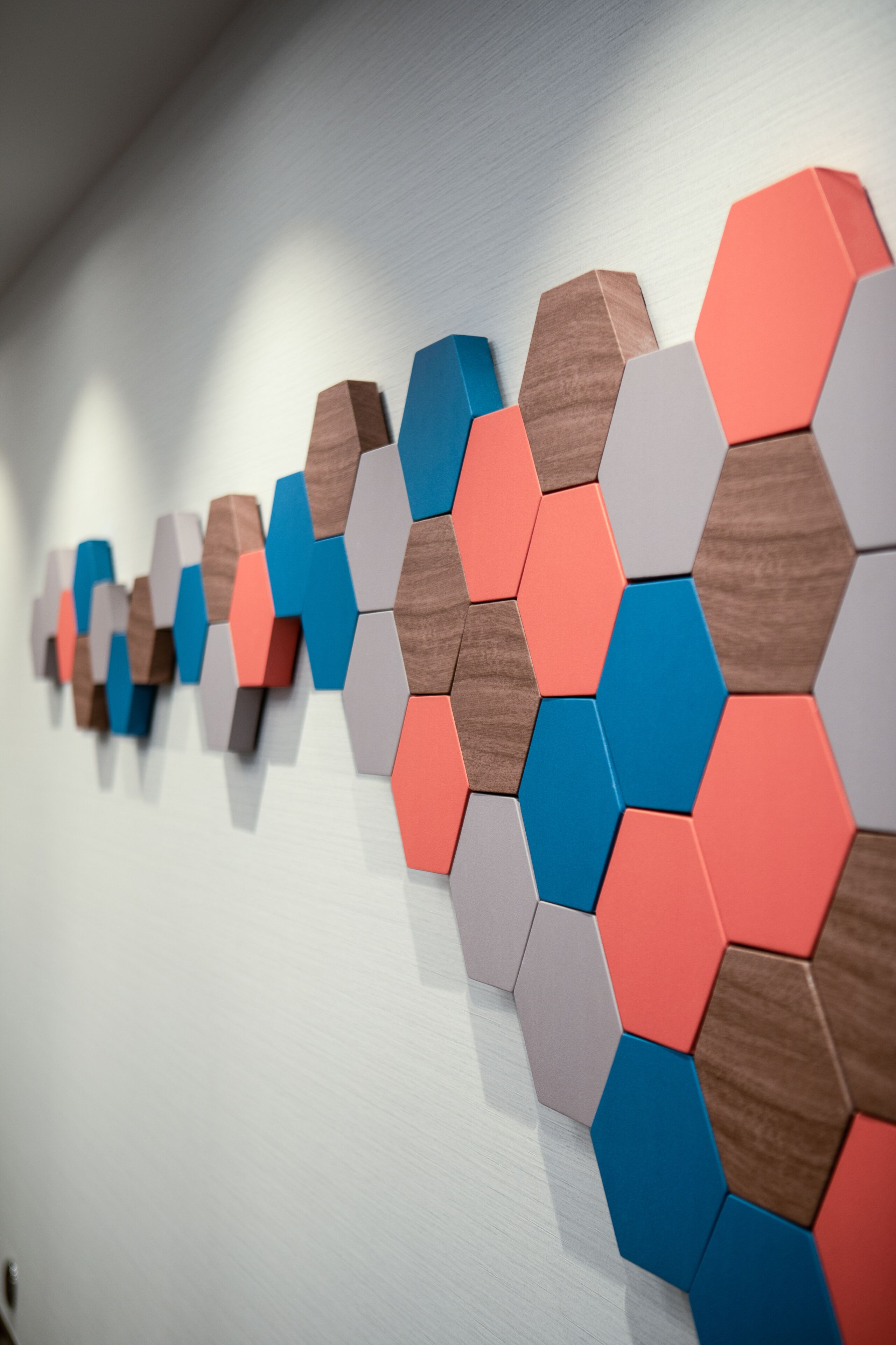 A wall with a geometric pattern of hexagonal shapes in various shades of brown, blue, and gray.