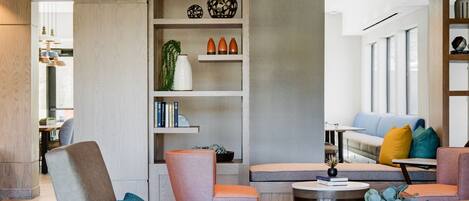 Una sala de estar moderna con un sofá gris, una mesa de centro redonda y una estantería.