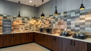 A modern kitchen with a patterned backsplash, wooden cabinets, and stainless steel appliances.