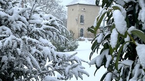 A snow-covered building with a turret, surrounded by snow-laden trees. - Gites de Gondières (Saint-Eloi)