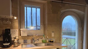 A kitchen with a window, a coffee machine, and a sink. - Gites de Gondières (Saint-Eloi)