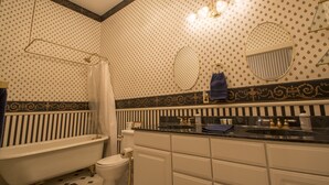 A bathroom with a bathtub, toilet, vanity with a mirror, and a shower curtain. - Entire Historical Bed and Breakfast in Rico, Cololorado (Rico)