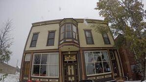 A corner building with a large bay window, a front door, and a sign reading "Mine Shaft Inn". - Entire Historical Bed and Breakfast in Rico, Cololorado (Rico)