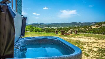 A hot tub with a clear view of a mountainous landscape in the background.