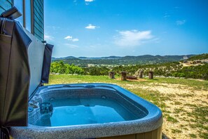 Ein Whirlpool mit freiem Blick auf eine gebirgige Landschaft im Hintergrund.