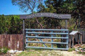 Ein Holzschild für die Antler Run Ranch mit einem Metalltor.