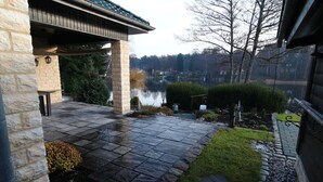 Une terrasse en pierre offrant une vue sur un lac et les arbres environnants.