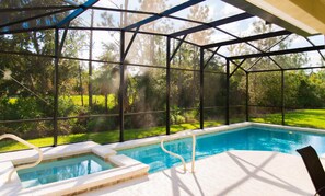 A covered swimming pool with a view of a forested area. - Trafalgar Retreat by Orlando Short Term (Kissimmee)