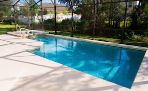 A rectangular swimming pool with clear blue water, surrounded by a white deck and a metal fence. - Trafalgar Retreat by Orlando Short Term (Kissimmee)