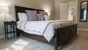 A bedroom with a bed, nightstands, a dresser, and a mirror. - Casablanca Villaview by Orlando Short Term (Kissimmee)