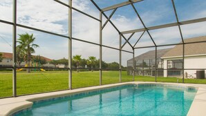 An indoor swimming pool with a clear view of the outside, surrounded by a metal frame structure. - Casablanca Villaview by Orlando Short Term (Kissimmee)