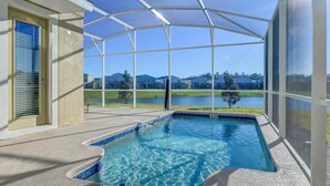 Piscina coberta com vista para um lago e casas ao fundo.