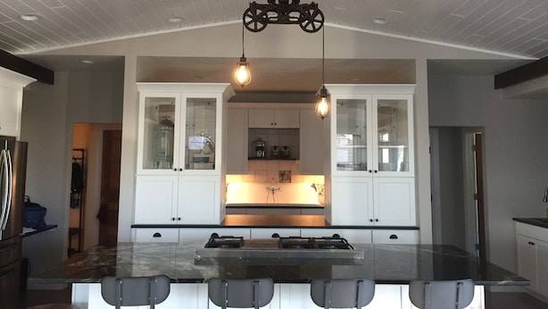 A spacious kitchen with a large island, white cabinetry, and pendant lighting. - Industrial chic farmhouse..... (Oshkosh)