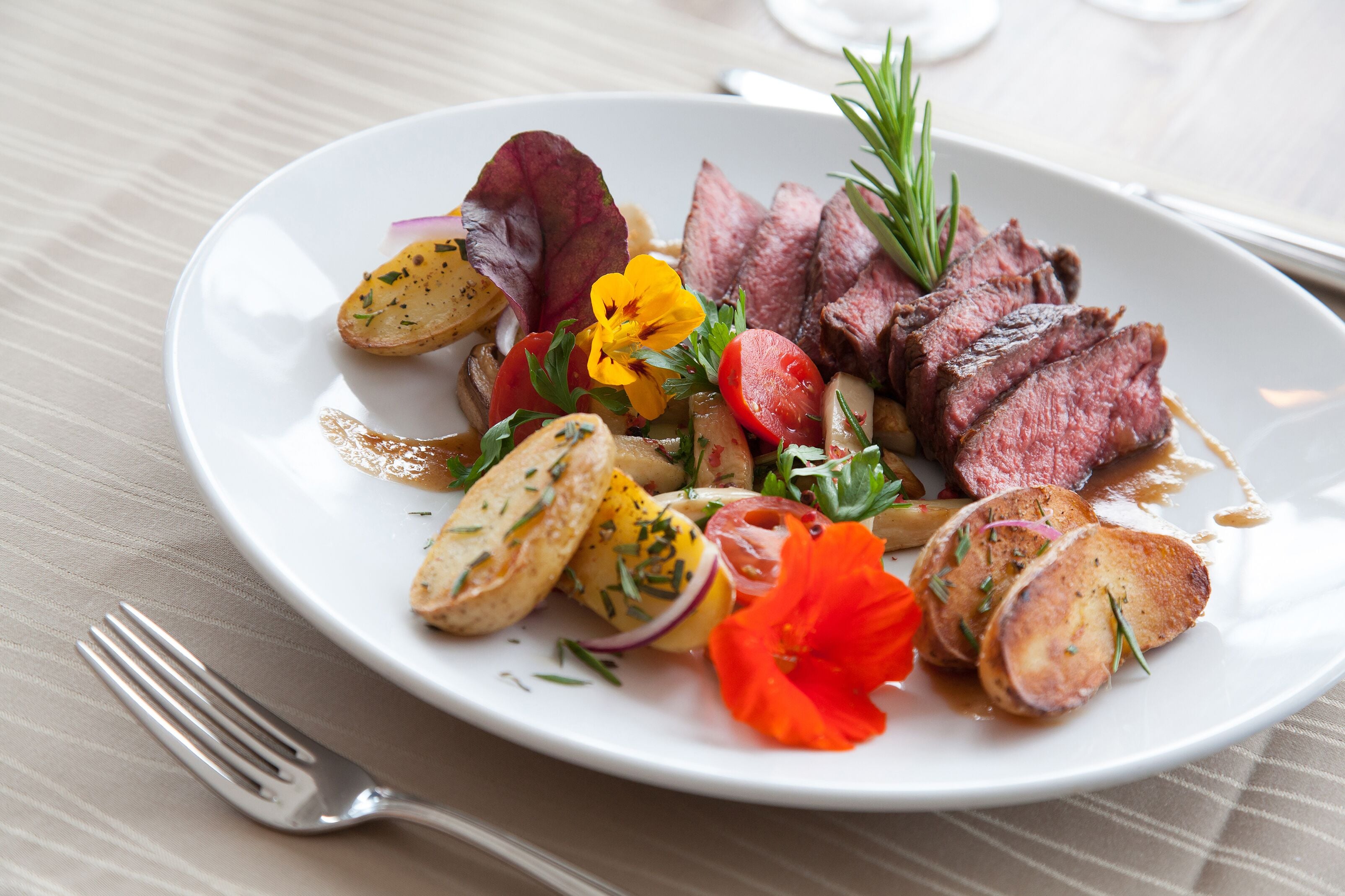 Un plato de comida con carne, papas y verduras.