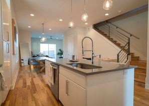 Enjoy cooking in this well-lit kitchen with a central island, stainless steel sink, and sleek faucet.