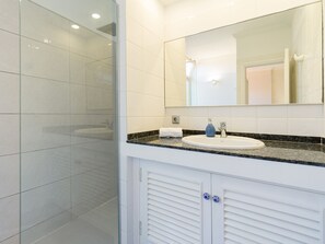 Regadera, secadora de cabello, toallas, papel de baño 